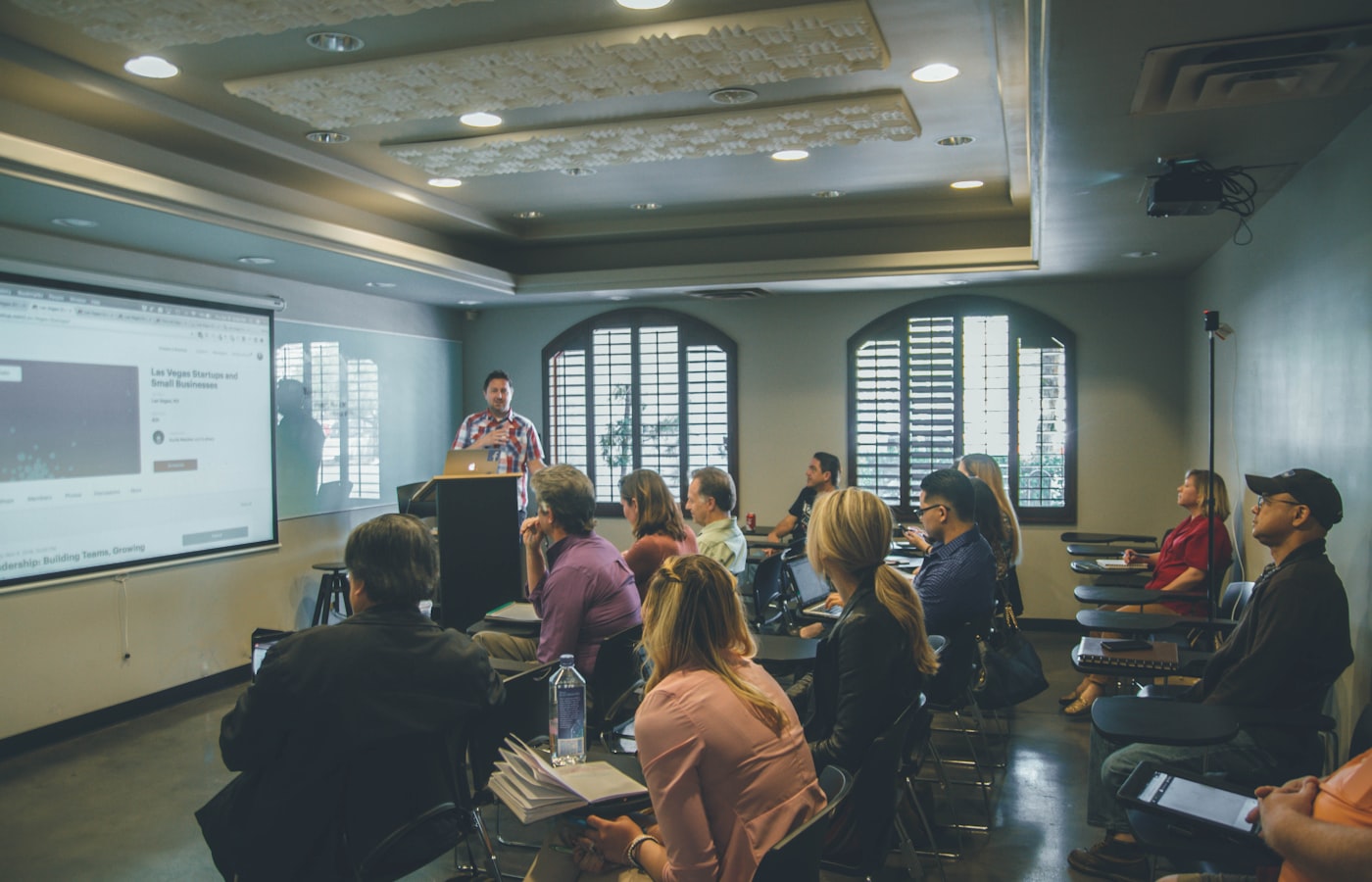 Corporate training workshop with a facilitator guiding a small executive group